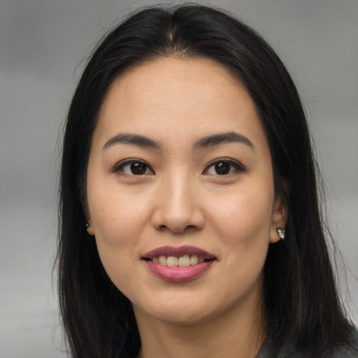 Joyful asian young-adult female with long  brown hair and brown eyes