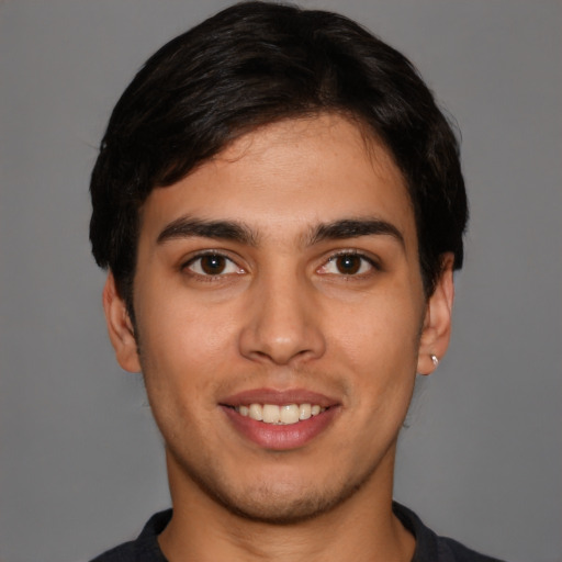 Joyful white young-adult male with short  black hair and brown eyes