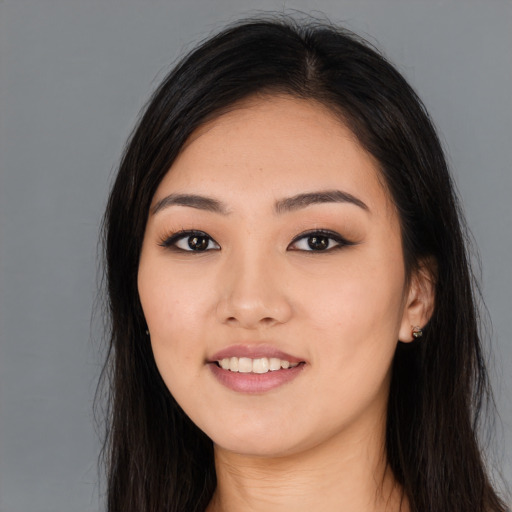 Joyful asian young-adult female with long  brown hair and brown eyes