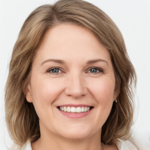 Joyful white young-adult female with medium  brown hair and green eyes