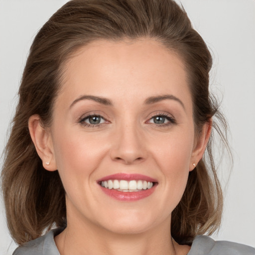 Joyful white young-adult female with medium  brown hair and grey eyes