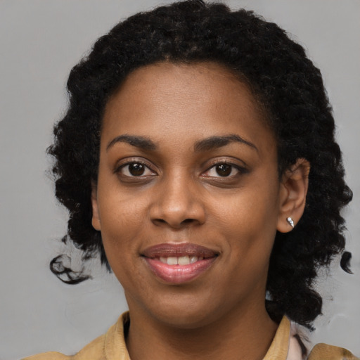 Joyful black young-adult female with short  black hair and brown eyes
