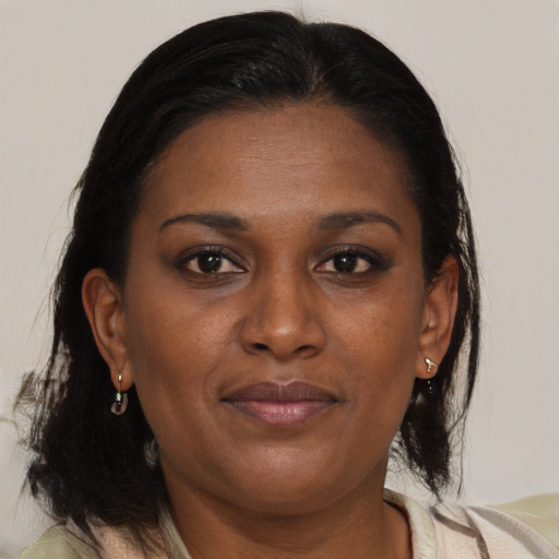 Joyful black adult female with medium  brown hair and brown eyes