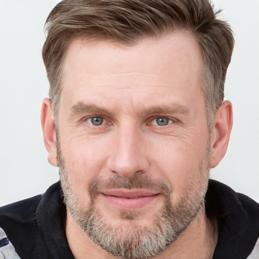 Joyful white adult male with short  brown hair and grey eyes