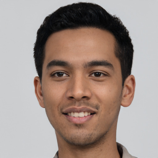 Joyful latino young-adult male with short  black hair and brown eyes