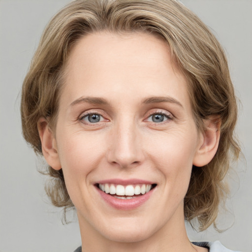 Joyful white young-adult female with medium  brown hair and blue eyes