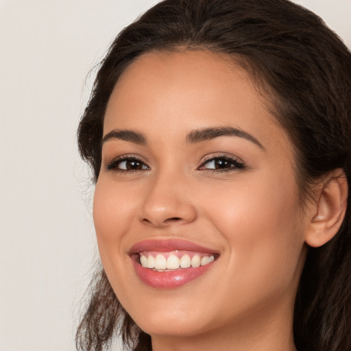 Joyful white young-adult female with long  brown hair and brown eyes