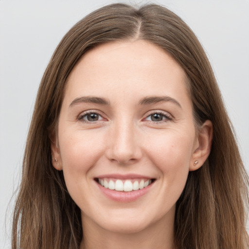 Joyful white young-adult female with long  brown hair and grey eyes