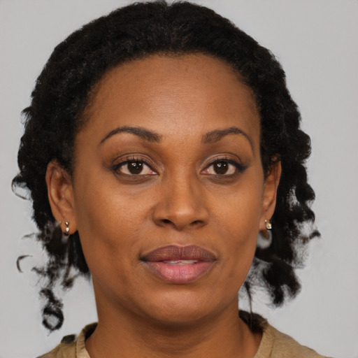 Joyful black adult female with medium  brown hair and brown eyes