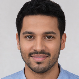 Joyful white young-adult male with short  black hair and brown eyes