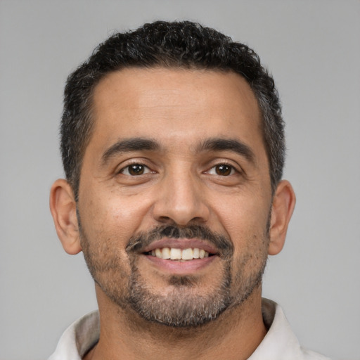 Joyful latino adult male with short  black hair and brown eyes