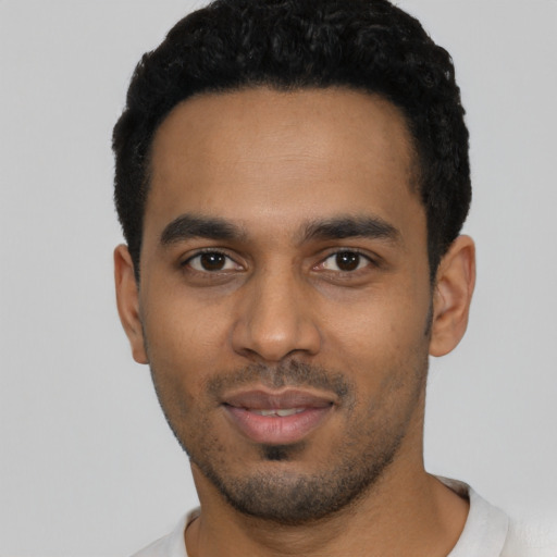 Joyful latino young-adult male with short  black hair and brown eyes