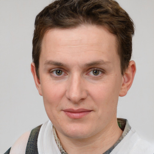 Joyful white young-adult male with short  brown hair and blue eyes