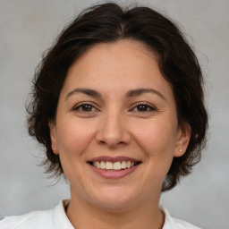 Joyful white adult female with medium  brown hair and brown eyes