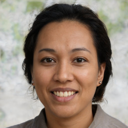 Joyful latino adult female with medium  brown hair and brown eyes