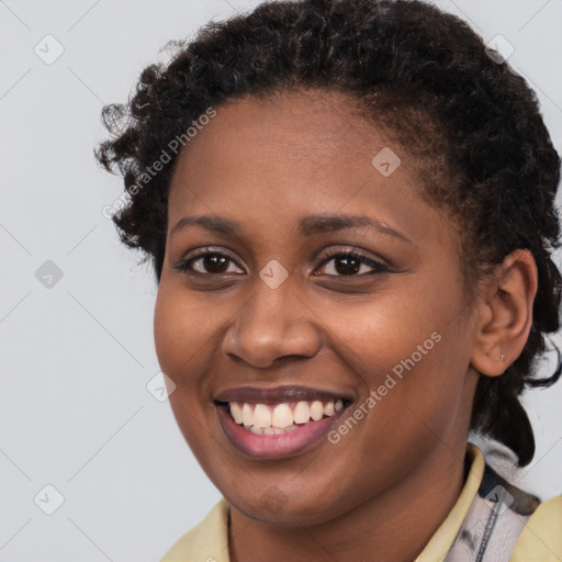 Joyful black young-adult female with short  brown hair and brown eyes