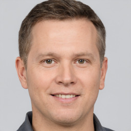 Joyful white adult male with short  brown hair and grey eyes