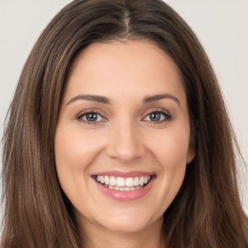 Joyful white young-adult female with long  brown hair and brown eyes