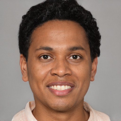 Joyful latino young-adult male with short  brown hair and brown eyes