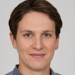 Joyful white adult male with short  brown hair and grey eyes