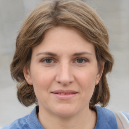 Joyful white young-adult female with medium  brown hair and blue eyes