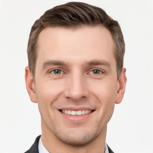 Joyful white young-adult male with short  brown hair and grey eyes