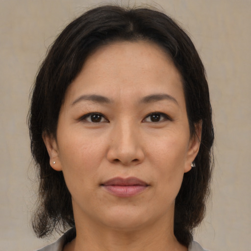 Joyful asian adult female with medium  brown hair and brown eyes