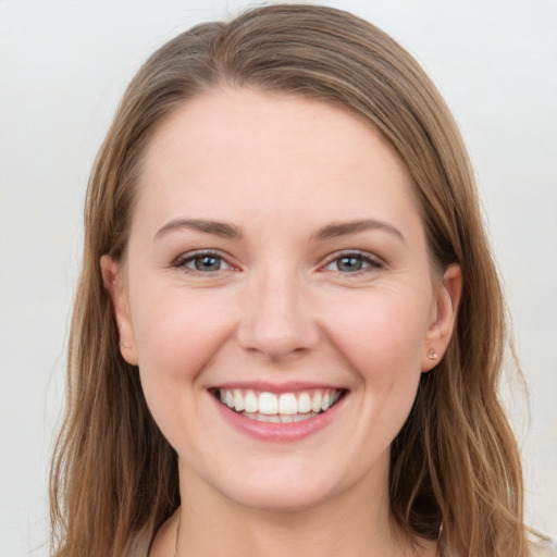 Joyful white young-adult female with long  brown hair and grey eyes