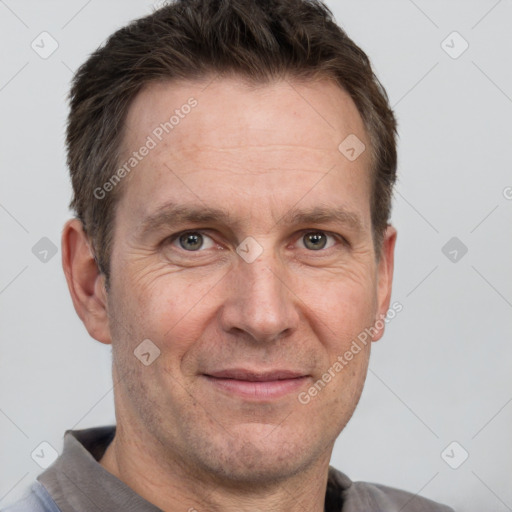 Joyful white adult male with short  brown hair and grey eyes