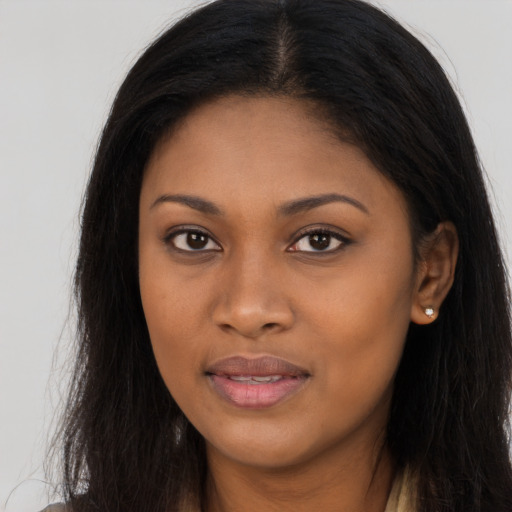 Joyful black young-adult female with long  brown hair and brown eyes
