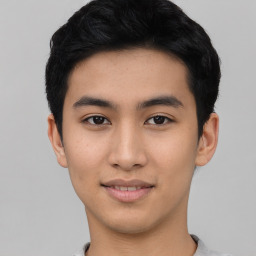 Joyful asian young-adult male with short  black hair and brown eyes