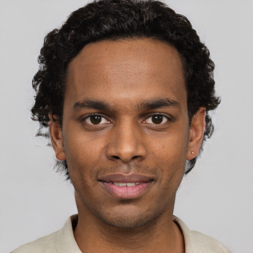 Joyful black young-adult male with short  brown hair and brown eyes
