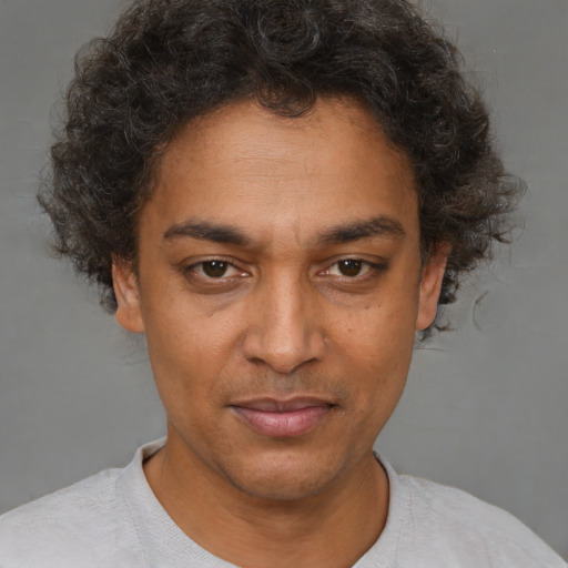 Joyful black adult male with short  brown hair and brown eyes