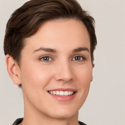 Joyful white young-adult female with short  brown hair and grey eyes