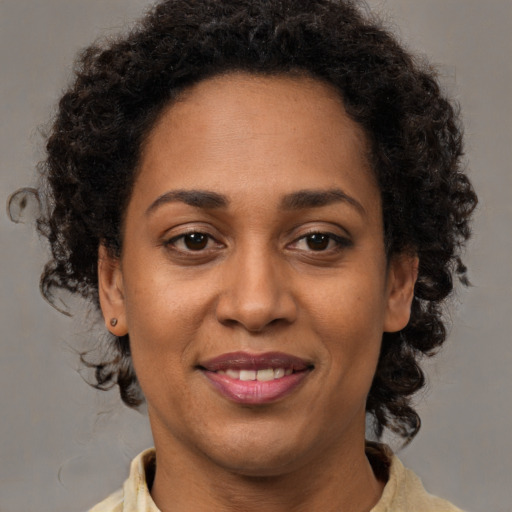 Joyful black young-adult female with medium  brown hair and brown eyes