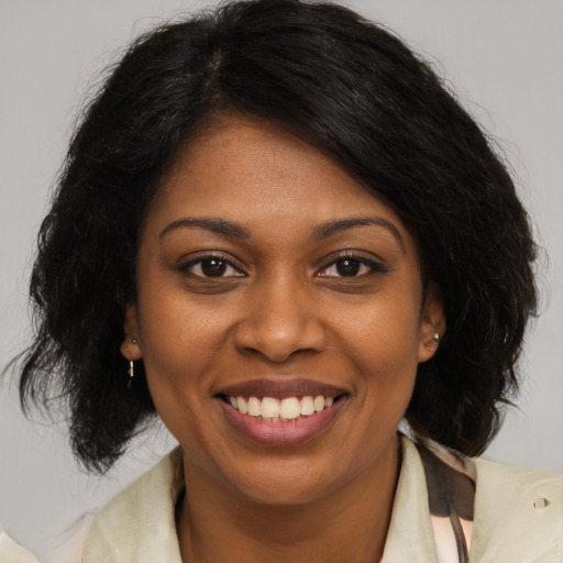 Joyful black young-adult female with medium  brown hair and brown eyes
