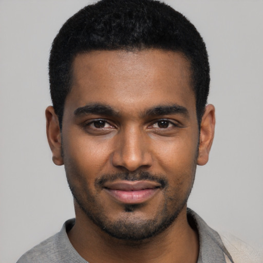 Joyful black young-adult male with short  black hair and brown eyes