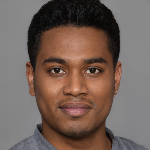 Joyful black young-adult male with short  black hair and brown eyes