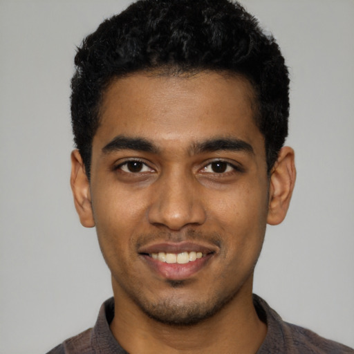 Joyful black young-adult male with short  black hair and brown eyes