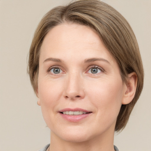 Joyful white adult female with medium  brown hair and green eyes