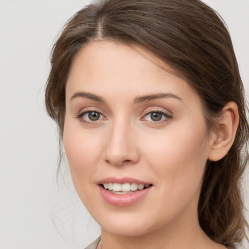 Joyful white young-adult female with medium  brown hair and grey eyes