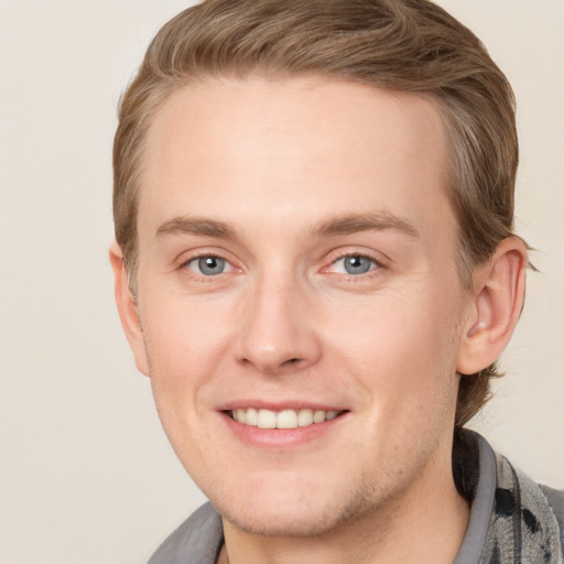 Joyful white young-adult male with short  brown hair and blue eyes