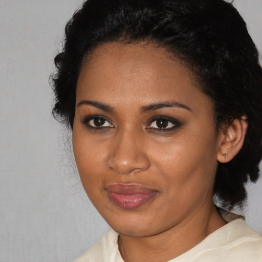 Joyful black adult female with short  black hair and brown eyes