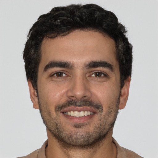 Joyful white young-adult male with short  black hair and brown eyes