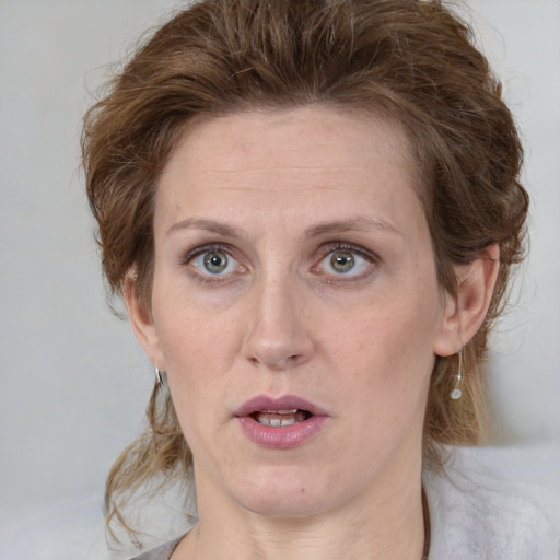 Joyful white adult female with medium  brown hair and green eyes