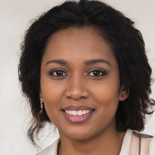 Joyful black young-adult female with long  brown hair and brown eyes