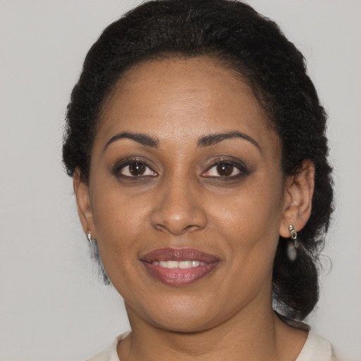 Joyful black young-adult female with medium  brown hair and brown eyes