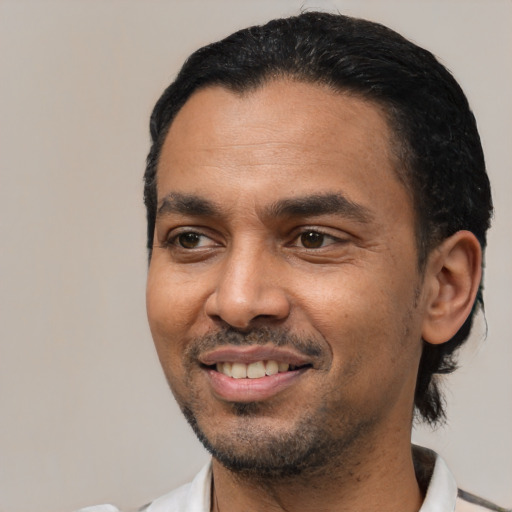 Joyful latino young-adult male with short  black hair and brown eyes