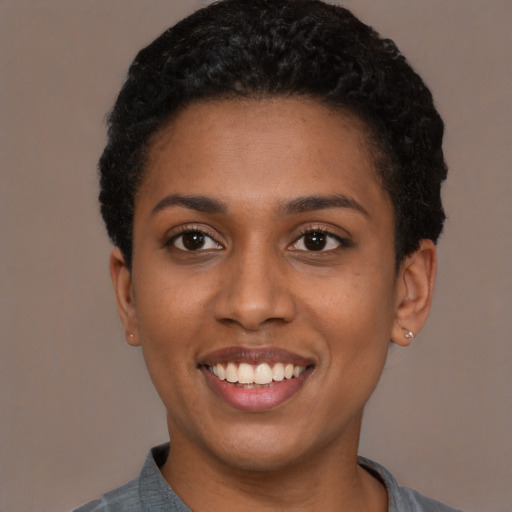 Joyful black young-adult female with short  black hair and brown eyes