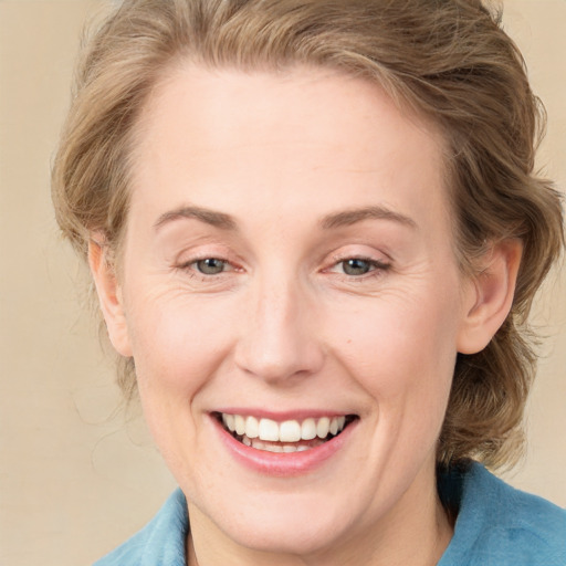 Joyful white adult female with medium  brown hair and grey eyes